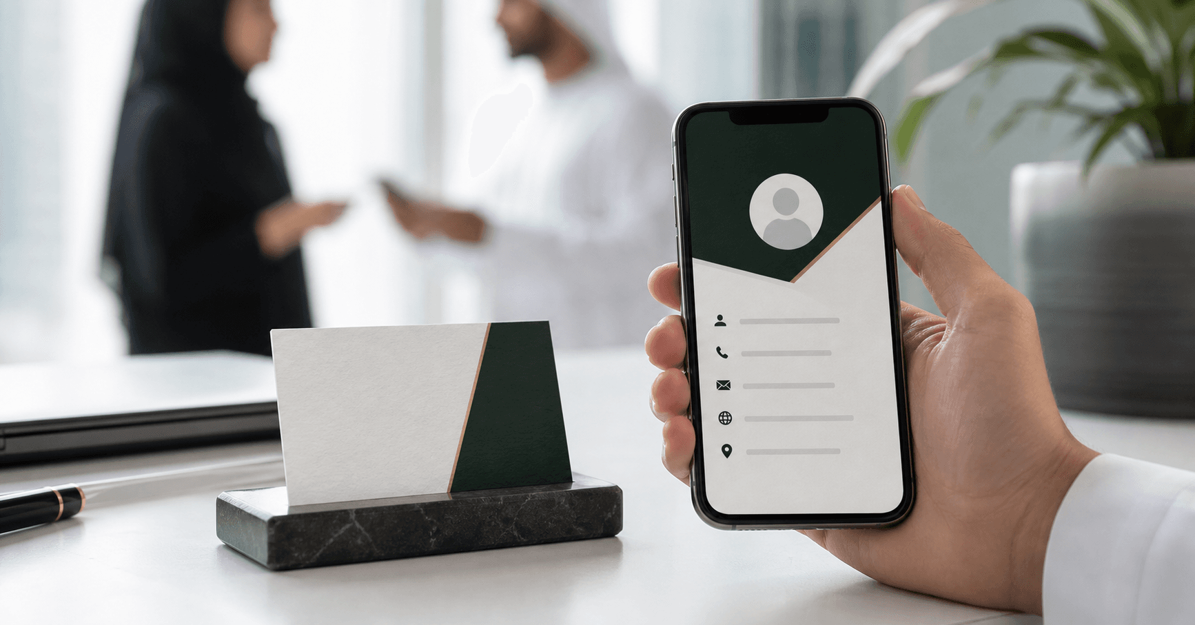 Digital business card displayed on a smartphone beside a paper business card in the UAE